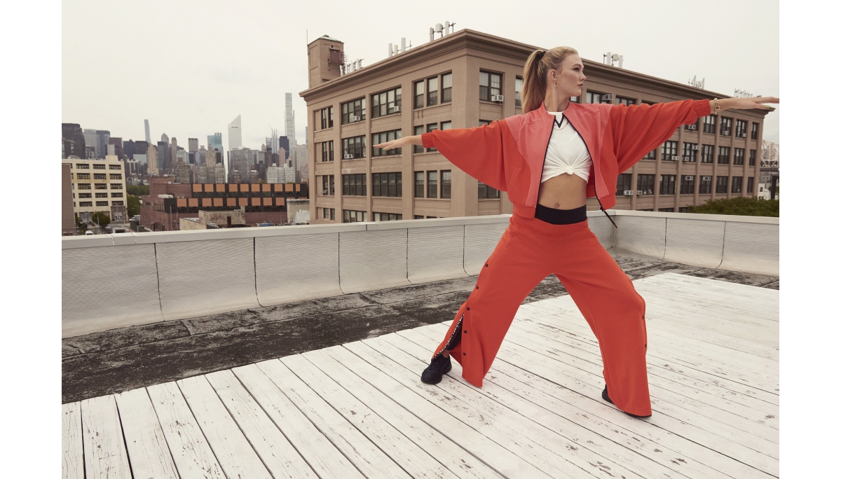 2. 國際級超模Karlie Kloss身著adidas x Karlie Kloss 2021春季聯名系列橘紅短版寬袖外套，內搭同系列白色短袖T-shirt，打造隨興修身視覺效果