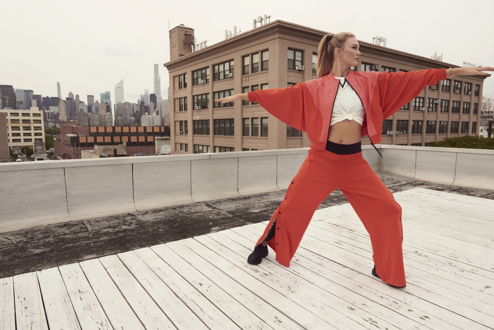 2. 國際級超模Karlie Kloss身著adidas x Karlie Kloss 2021春季聯名系列橘紅短版寬袖外套，內搭同系列白色短袖T-shirt，打造隨興修身視覺效果